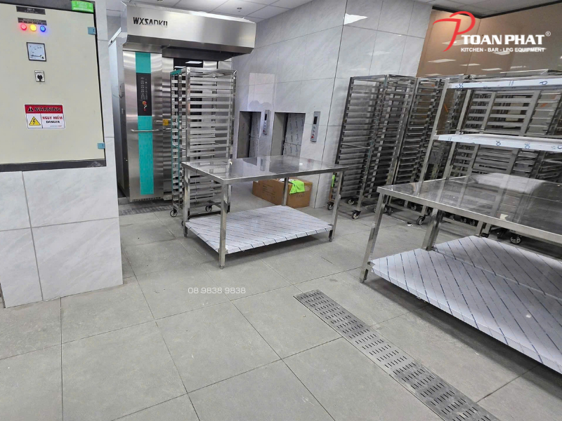 Bàn, kệ và xe đẩy khay trong khu bếp bánh