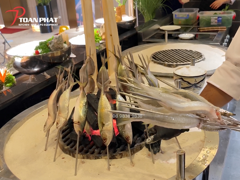 Hình ảnh thực tế bếp nướng công nghiệp dùng cát tại Buffet Cửu Vân Long Premium - Saigon Marina IFC